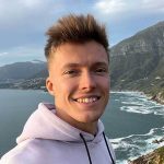 Nuori mies taustallaan merta ja vuoristoa.